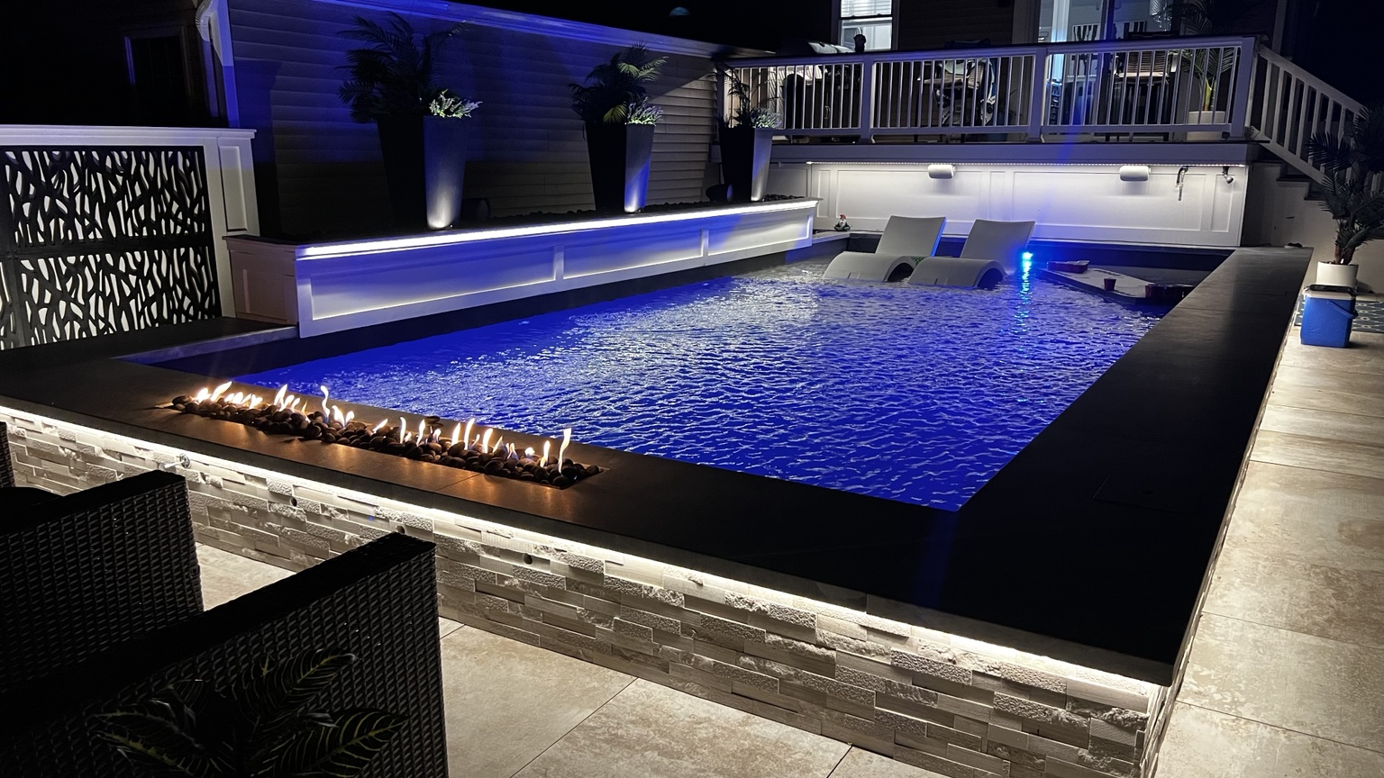 Complete luxury backyard design with swimming pool, fire and water features and landscape lighting in Dix Hills, Long Island