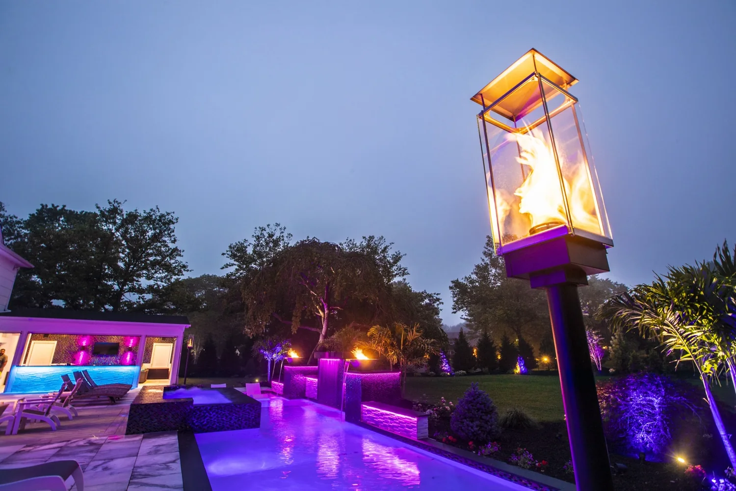 Tempest Torch fire feature beside a luxury Long Island swimming pool