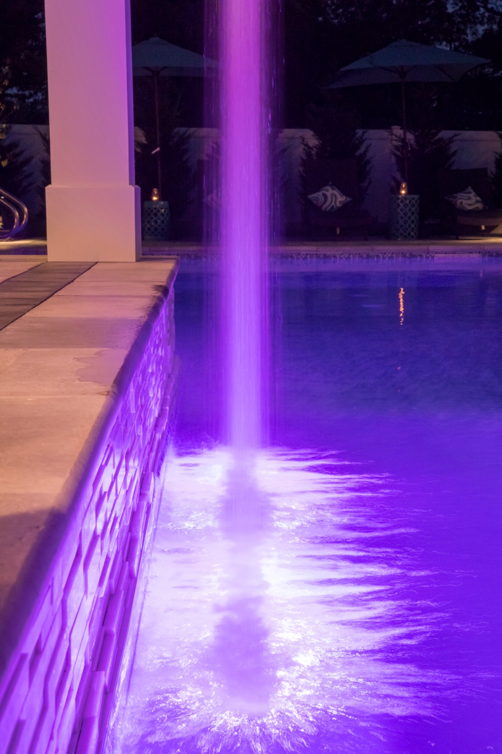 Close-up of illuminated rain curtain entering the pool