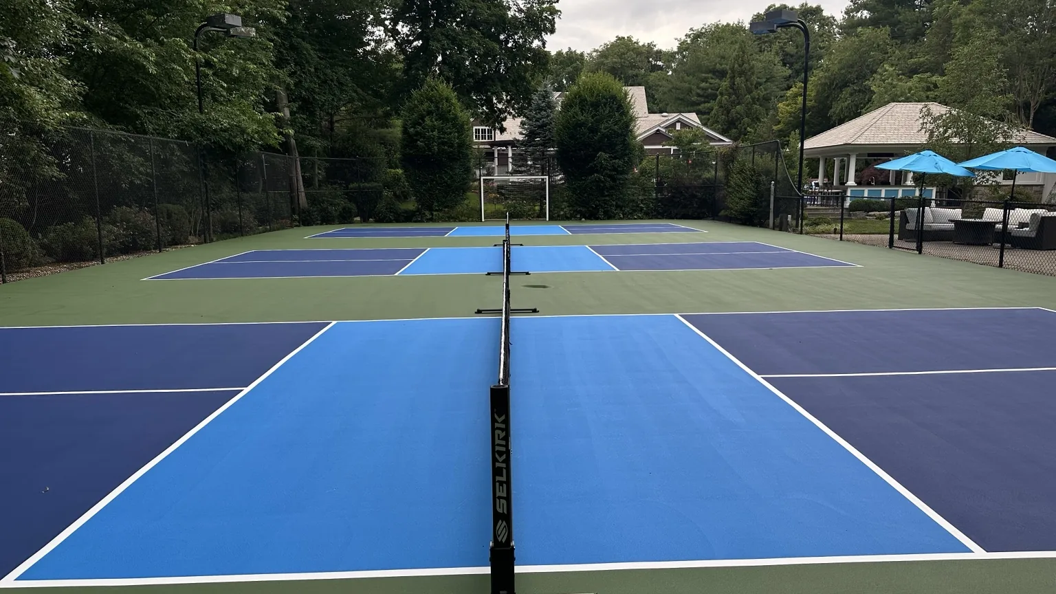 Completed residential pickleball courts with blue and green DecoTurf colors in Melville NY