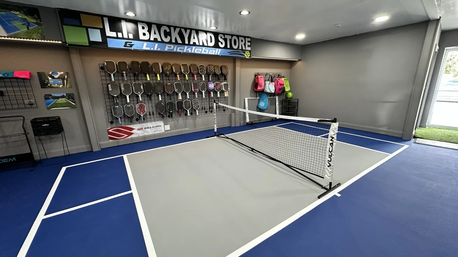 L.I. Pickleball indoor demo court and paddle wall at Melville showroom