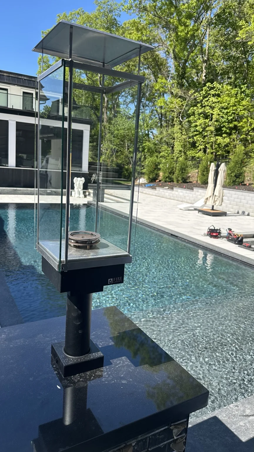 Tempest Torch mounted on a finished black masonry pool pillar