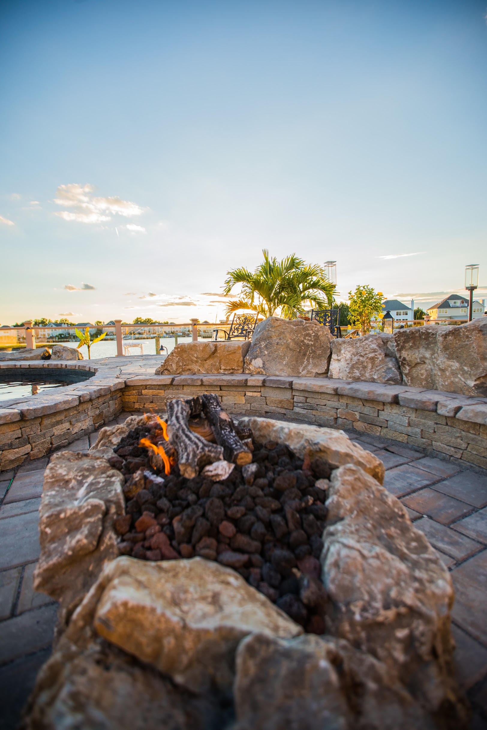 Stone fire pit seating area overlooking waterfront