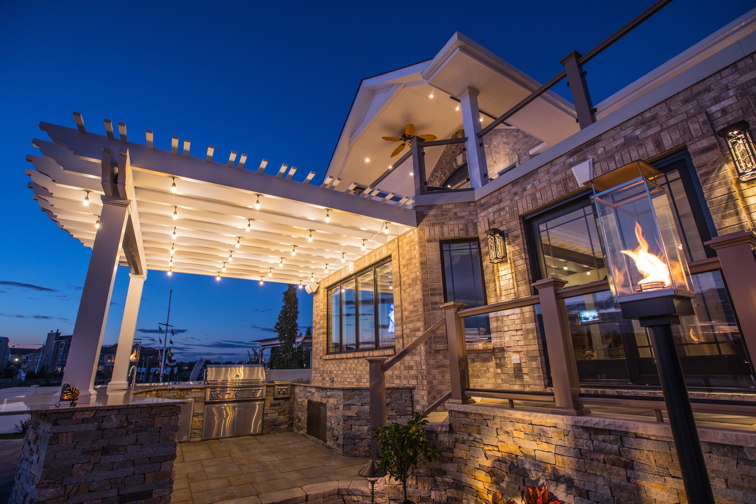 Outdoor kitchen and pergola illuminated at night